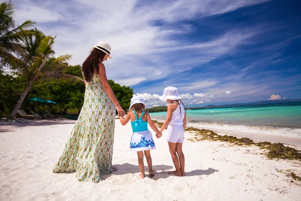 Visão traseira de duas meninas e sua mãe em uma praia branca e tropical — Fotografia de Stock