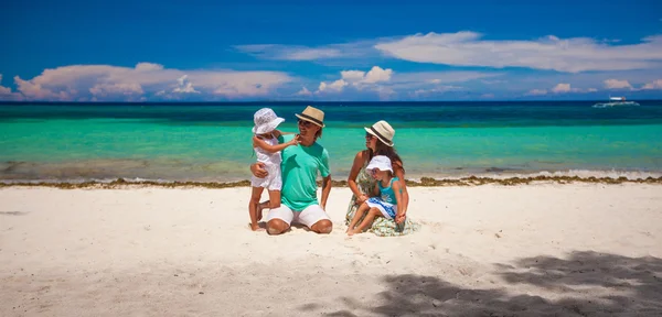 Čtyřčlenná rodina na dovolené na pláži — Stock fotografie