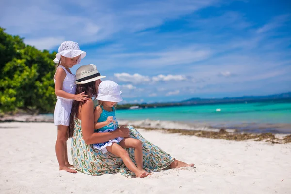 Rear view of fashion young mother and two her kids at exotic beach on sunny day — Stock Photo, Image
