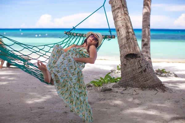 Mujer joven feliz acostada en la hamaca en la playa tropical — Foto de Stock