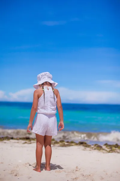 Schattig klein meisje alleen kijkt naar de zee op witte strand — Stockfoto