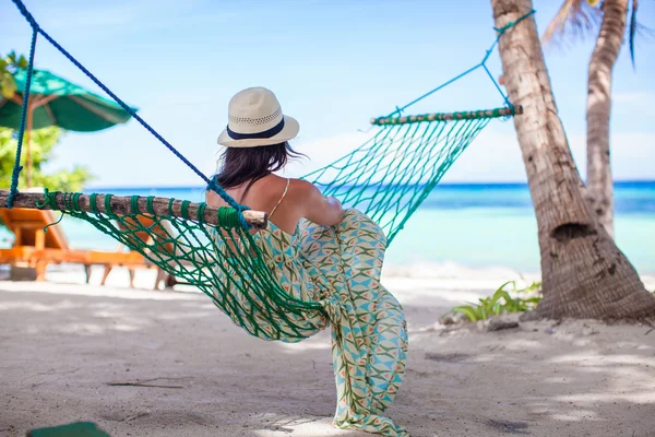 Vista trasera de la mujer joven disfrutando de un día soleado en la hamaca —  Fotos de Stock