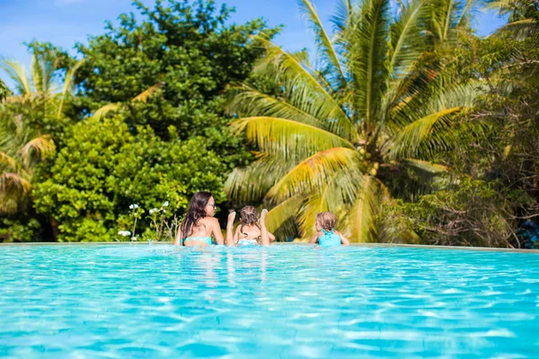 Madre con due dei suoi figli rilassarsi nella cacca di lusso tranquilla piscina — Foto Stock