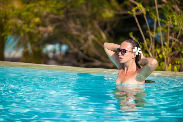 Jovem mulher bonita desfrutando da piscina tranquila de luxo — Fotografia de Stock