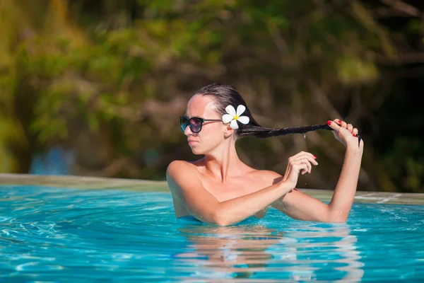 Portret van jonge mooie vrouw genieten van het rustige zwembad van luxe — Stockfoto