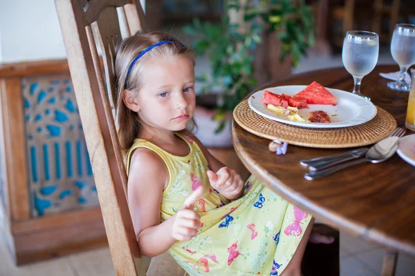 Adorable little girl having breakfast in exotic resort — Stock Photo, Image