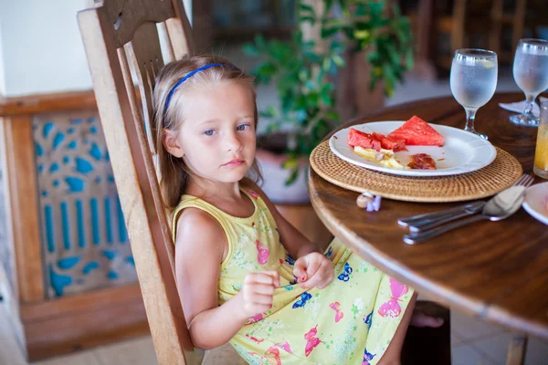 Adorable niña desayunando en el restaurante del resort —  Fotos de Stock