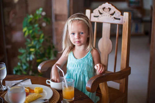 Adorável menina tomando café da manhã e bebendo coquetel de frutas — Fotografia de Stock