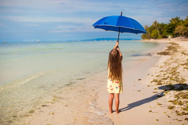 Niña linda con gran paraguas azul caminando en una playa tropical — Foto de Stock