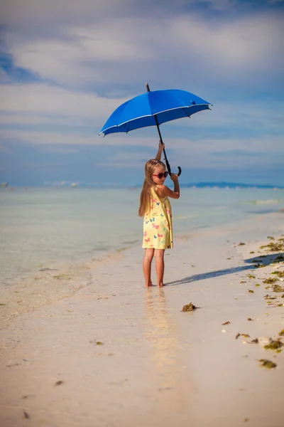 Roztomilá holčička s deštníkem bavit na exotické pláži — Stock fotografie