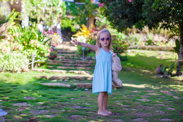 Little girl walking in tropical green hotel