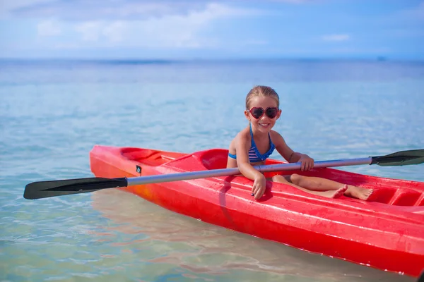 Pequena menina bonito corajoso flutuando em um caiaque no alto mar azul — Fotografia de Stock