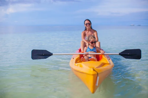 Deux enfants avec leur mère sur un bateau flottant dans la mer claire — Photo