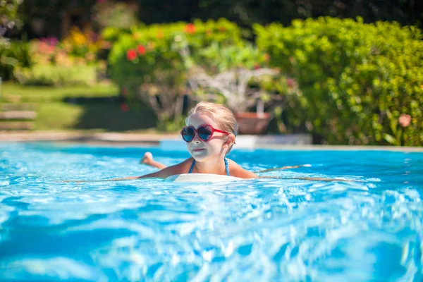 Kleines entzückendes glückliches Mädchen schwimmt im Schwimmbad — Stockfoto