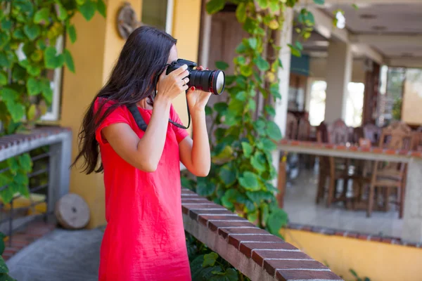 Młoda brunetka kobieta z aparatem na dziedzińcu piękny dom — Zdjęcie stockowe