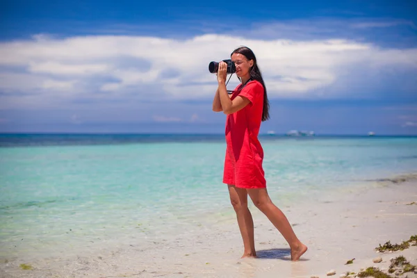 Profile of young woman photographed beautiful seascape on white sand beach — Stock Photo, Image