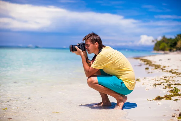 Jovem tirando fotos em uma praia tropical — Fotografia de Stock