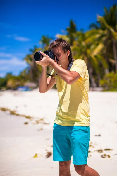 Joven tomando fotos en una playa tropical — Foto de Stock