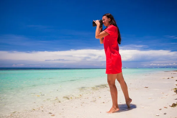Młoda kobieta fotografować morze na białej, piaszczystej plaży — Zdjęcie stockowe
