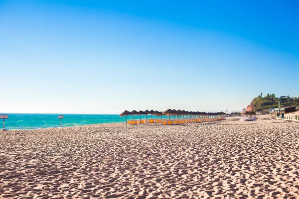Пустой пляж с закрытыми зонтиками ранним утром на португальском побережье — стоковое фото