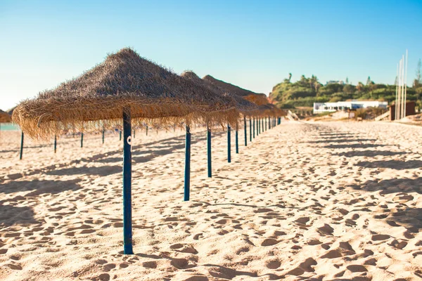 Stro paraplu's op lege tropisch strand aan de Atlantische kust — Stockfoto