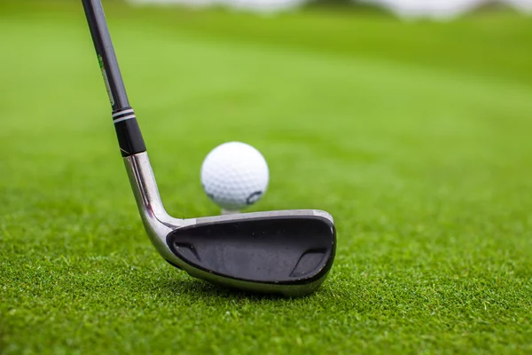 Golf stick en bal op groen gras — Stockfoto