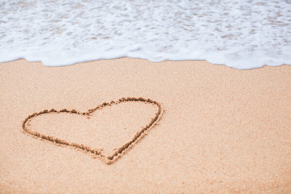 Heart painted in the sand on a tropical beach