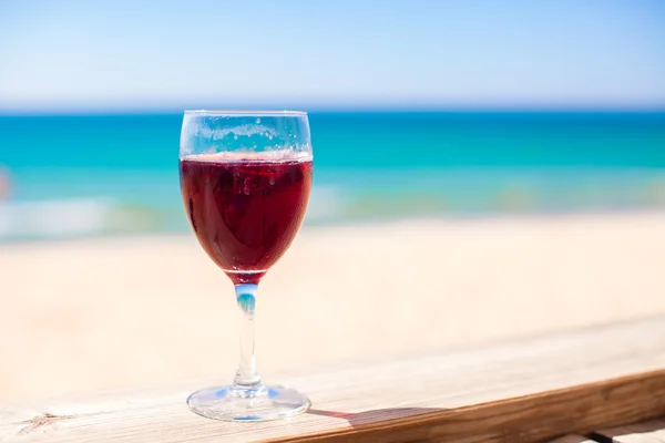 Glas Rotwein gegen das türkisfarbene Meer — Stockfoto