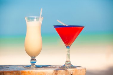 İki kokteyl: pina colada ve ahşap masa üzerinde çilek margarita