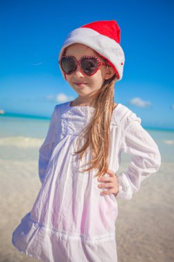 küçük kız kırmızı şapka Noel Baba ve egzotik plaj güneş gözlüğü