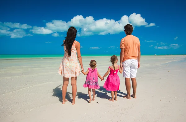 Back view family of four on caribbean beach vacation — Stock Photo, Image