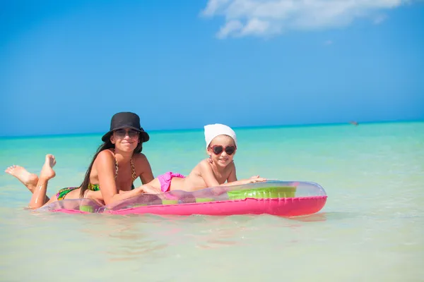 Little girl with young mother on an air mattress in the sea — Stock Photo, Image