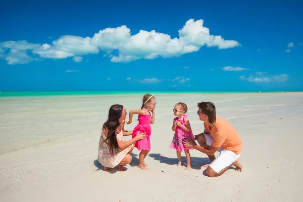 Jovem bela família com duas filhas se divertindo na praia — Fotografia de Stock