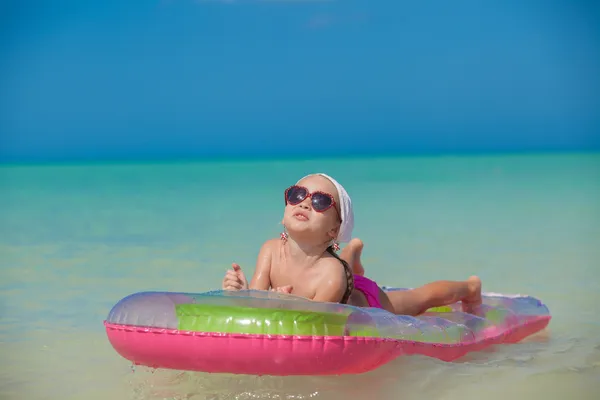 Niña linda relajarse en la cama de aire rosa en el mar caliente —  Fotos de Stock