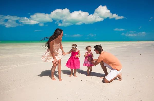 Joven hermosa familia con dos hijas divirtiéndose en la playa — Foto de Stock