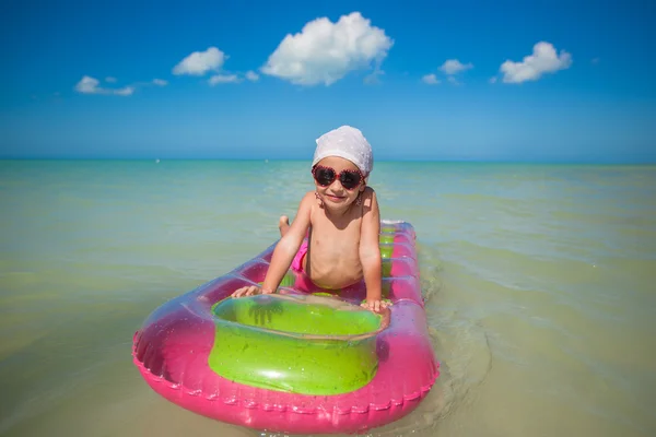 Roztomilá holčička na růžové vzduch lůžko v Karibském moři — Stock fotografie