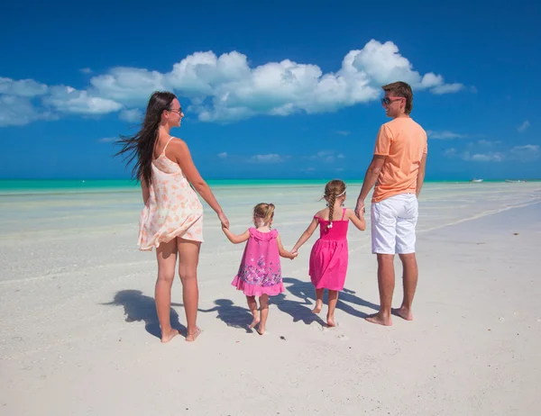 Back view family of four on caribbean beach vacation — Stock Photo, Image