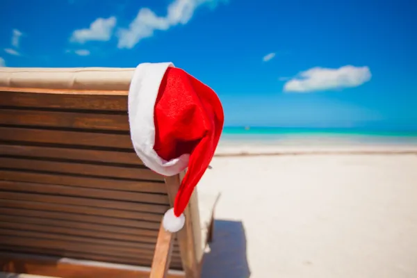 Cappello Babbo Natale sulla sedia a sdraio sulla spiaggia tropicale dei caraibi — Foto Stock