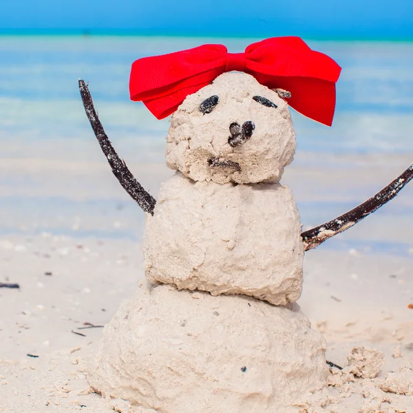白のカリブ海ビーチに弓と小さな砂浜雪だるま — ストック写真