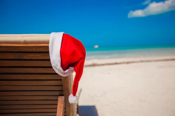 Närbild av santa hatt på stol longue på tropical caribbean beach — Stockfoto