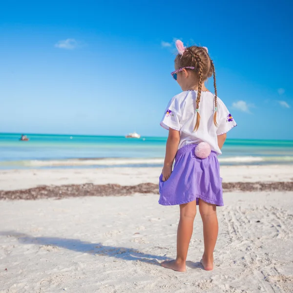 可爱的小女孩，在复活节服装在异国风情的沙滩上 — 图库照片