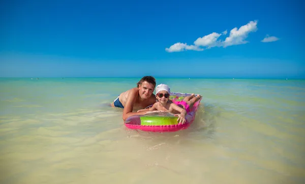 Holčička s mladým otcem na nafukovací matrace v moři — Stock fotografie