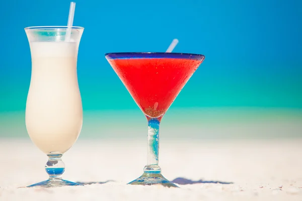 Zwei Cocktails: Pina Colada und Erdbeermargarita am weißen Sandstrand — Stockfoto