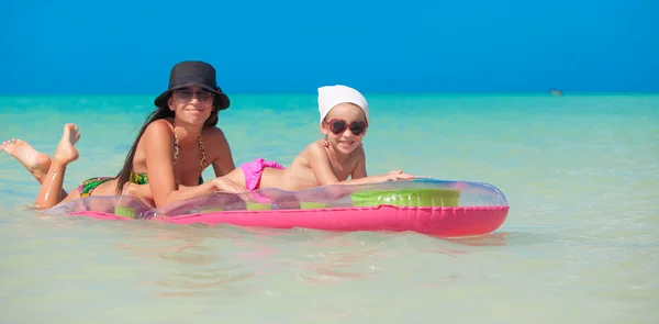 Little girl with young mother on an air mattress in the sea — Stock Photo, Image