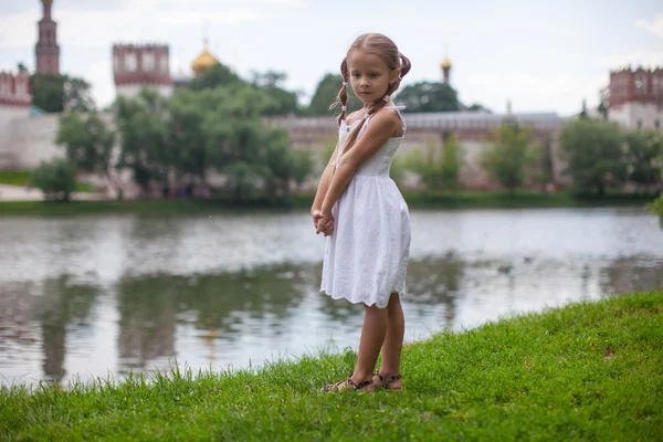 Liten blyg flicka promenader utomhus nära sjön — Stockfoto