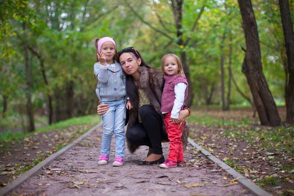 Junge Mutter mit ihren kleinen Töchtern vor der Kamera — Stockfoto