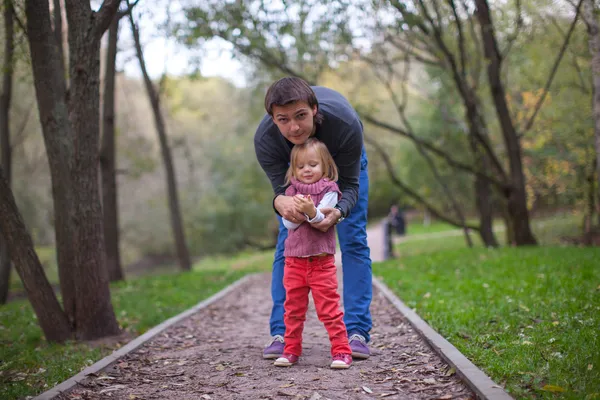 年轻的爸爸在公园在温暖的秋日的小女孩 — 图库照片