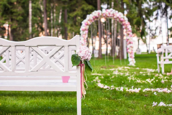 Bancos de casamento e arco de flores para cerimônia ao ar livre — Fotografia de Stock