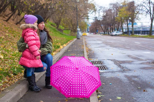 Petite fille et sa dame de chambre marchant avec un parapluie un jour de pluie — Photo