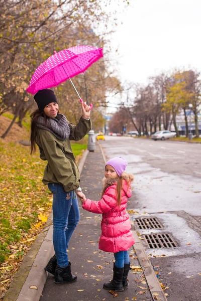 Ragazzina che cammina con la madre accompagnatrice sotto un ombrello in una giornata piovosa — Foto Stock